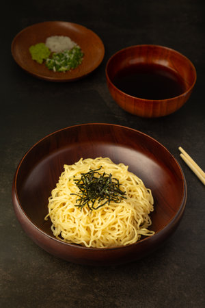 Japanese cold ramen noodles or Zaru Soba with chopped green onions, grated wasabi and cup for...