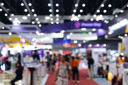 Abstract blur people in exhibition hall event trade show expo background. Business convention show, job fair, or stock market. Organization or company event, commercial trading, or shopping mall marketing advertisement concept.の写真素材
