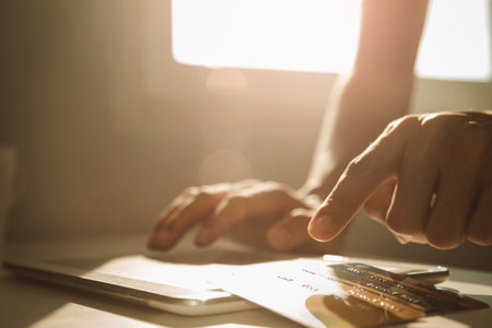 Male hands using tablet computer and choosing credit card at working desk for online shopping while break from work at home, E-commerce, Internet banking..の写真素材