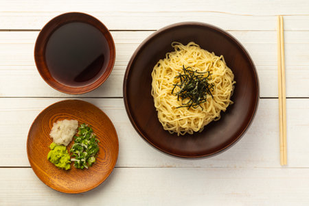 Japanese cold ramen noodles or Zaru Soba with chopped green onions, grated wasabi and cup for...