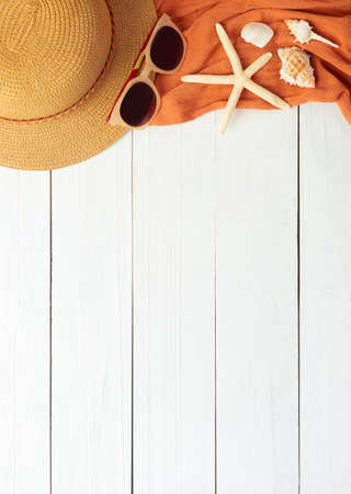 Summer background with beach accessories - straw hat, sunglasses, towel on white wood table background top view with copy space.の写真素材