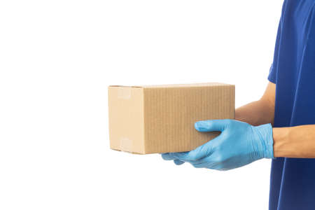 Closeup delivery man hand in medical gloves holding cardboard box isolated on white background,...