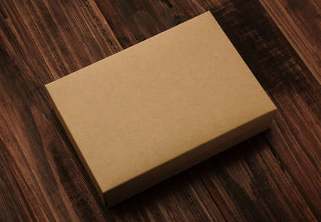 Blank cardboard brown box, Kraft paper box mockup on wooden background.の写真素材