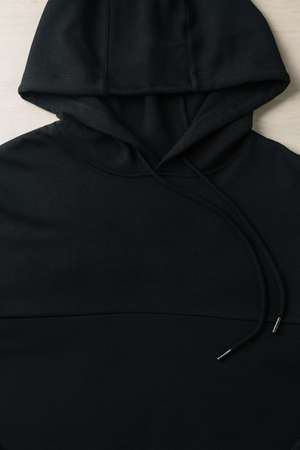 Closeup of blank black hoodie sweatshirt long sleeve mockup plank on the floor. Template for place...