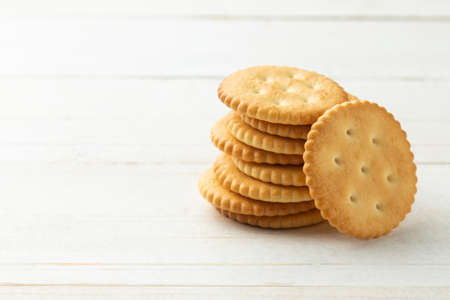 Rounded Cracker cookies on white wooden table background.の写真素材