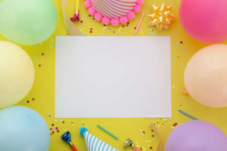 Happy birthday background, Flat lay colorful party decoration with flyer invitation card on pastel yellow background.の写真素材
