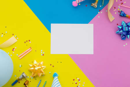 Happy birthday background, Flat lay colorful party decoration with flyer invitation card on pastel yellow, blue and pink geometric background.の写真素材