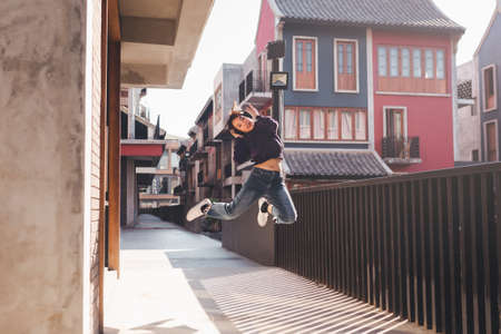 Happy young asian woman listening to music and having fun with headphones on the street.の写真素材