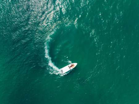 Aerial view of Speed boat in the aqua sea making a circle, Drone view.