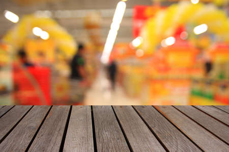 blurred image wood table and abstract generic supermarket people walking shoppingの写真素材