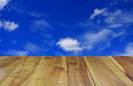 blurred image wood table and abstract clouds in the blue sky backgroundの写真素材