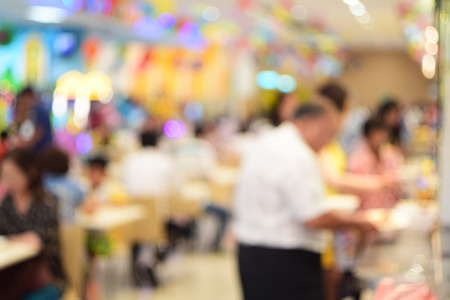 blurred photo of people in food center with light bokehの写真素材