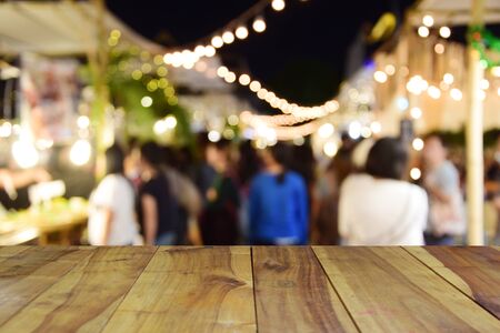 blurred image wood table and food at night festival with bokeh backgroundの写真素材