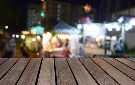 blurred image wood table and food at night festival with bokeh background
