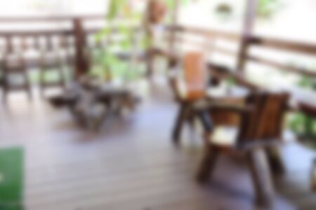 blur image woodden chair and table setting on a terraceの写真素材