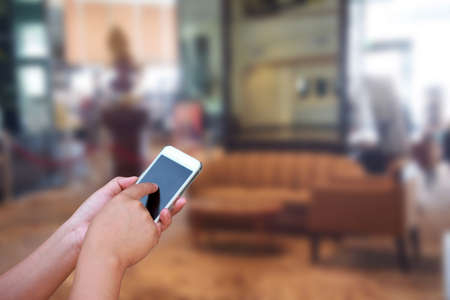 blurred photo and smartphone on hotel lobby background