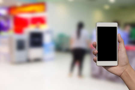 blurred photo and smartphone on Shopping mall backgroundの写真素材