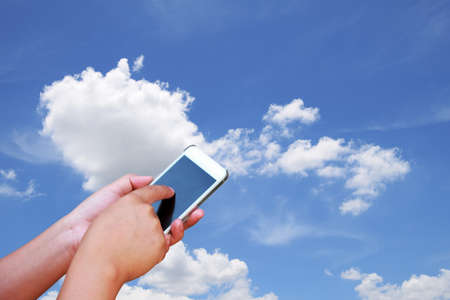 photo hand and smartphone on nice blue sky with cloud, background