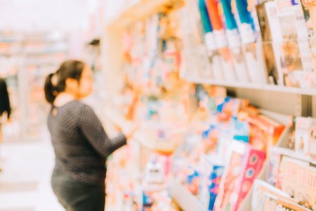 Blurred image abstract people and bookshelves in library as backgroundの写真素材