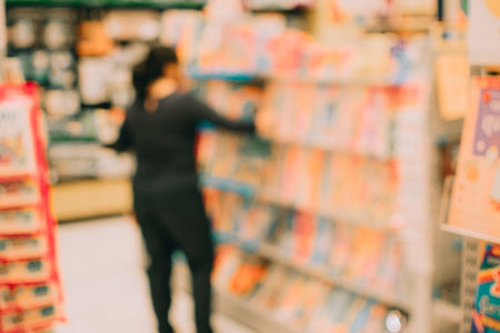 Blurred image abstract people and bookshelves in library as backgroundの写真素材
