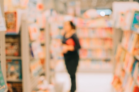 Blurred image abstract people and bookshelves in library as backgroundの写真素材