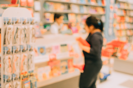 Blurred image abstract people and bookshelves in library as backgroundの写真素材