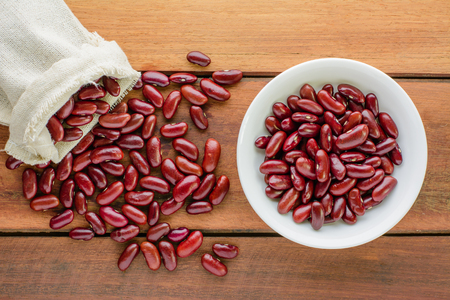 Top view of red beans in sack and bowl on wooden table. Healthy and nutrition food concept,cooking concept.の写真素材