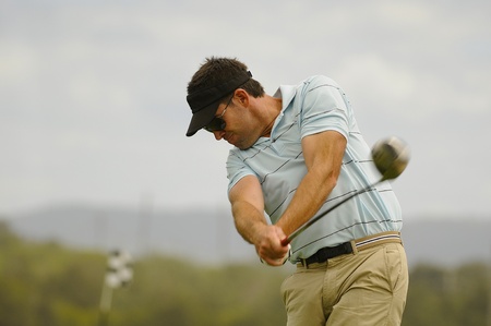 Golfer swings his driver off the tee