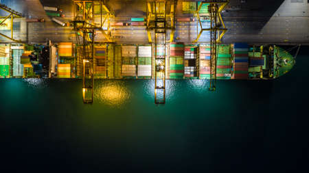 shipping port and shipping containers cargo transportation import and export international service by the sea at night aerial viewの写真素材