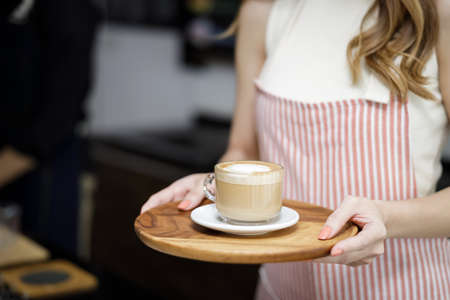 Close up women holding cup of coffee mug latte at coffee shop