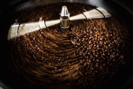 roasted  spinning cooler professional machines and fresh brown coffee beans movement close up dark...