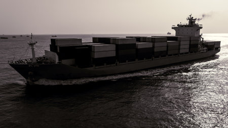 black and white of cargo container ship sailing full speed in sea and over background to import...