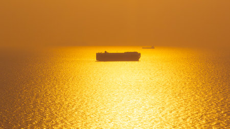Aerial view Roll on Roll off vehicle car carrier, Seascape over colorful and silhouette Roll on Roll off vehicle car carrier floating in sea in the golden hour time,の写真素材