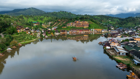 Beautiful aerial view of hills and Chinese buildings in Ban Rak Thai Village and small raft tourist at Ban Rak Thai Resort, Mae Hong Son, Thailandの写真素材