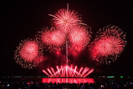 PATTAYA, CHONBURI, THAILAND Beautiful colorful fireworks night scene at Pattaya International Fireworks Festival and silhouette Group of tourist take pictures of firework show on the beach,の写真素材