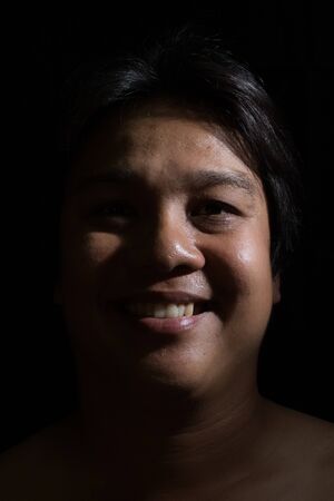 Portrait of a man smiling with in studio black background