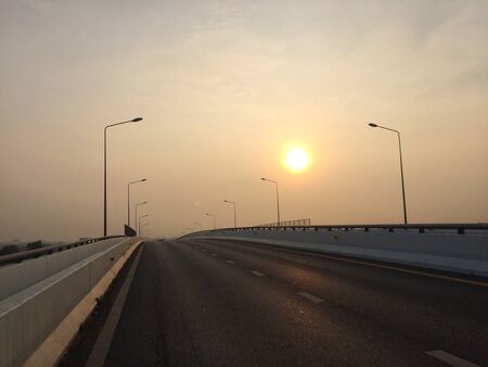The morning sun on the road on the bridge every dayの写真素材
