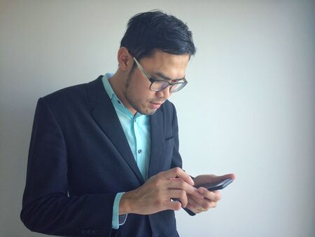 Businessman using mobile phone outside of office. man holding smartphone for business work.の写真素材