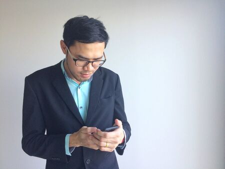 Businessman using mobile phone outside of office. man holding smartphone for business work.の写真素材