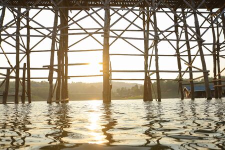 Silhouette Mon wooden bridge Songkalia river with twilight sky at dusk in Sangkhlaburi, Kanchanaburi, Thailandの写真素材