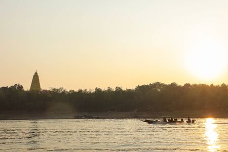 Sunset on reservoir with tourist boat twilight sky at dusk in Sangkhlaburi, Kanchanaburi, Thailandの写真素材