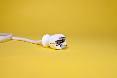 White power cable with plug on yellow backgroundの写真素材