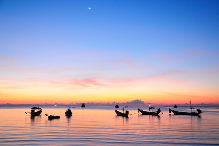 Golden sunset on a sea with silhouette of ships at Suratthaniの写真素材