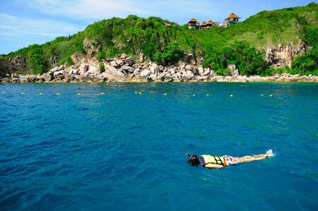 woman free diving snorkeling in beautiful blue oceanの写真素材