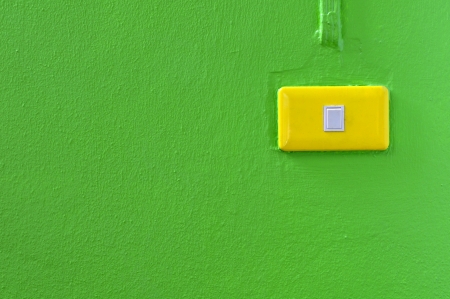 light switch on a green wallの写真素材