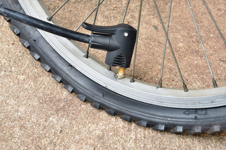 Pumping air into tire of bicycleの写真素材