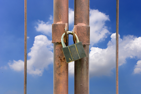 lock key on rusty fence and blue sky backgroundの写真素材