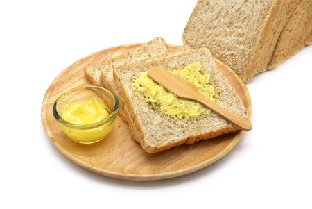 Isolated whole wheat bread and butter in a wooden bowlの写真素材