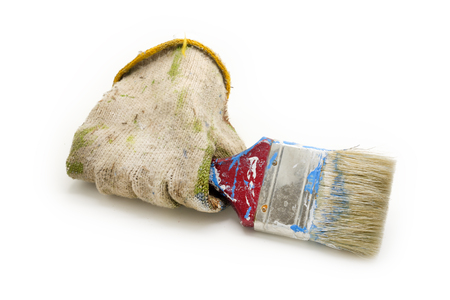 dirty cloth gloves hold used paint brush isolated on white backgroundの写真素材