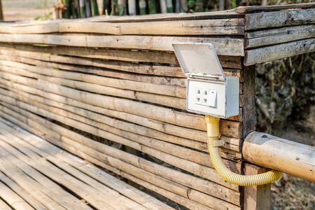 Outdoor old lighting switch on bamboo panel, rail switches, outlet plugsの写真素材